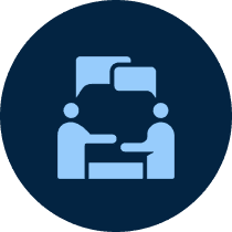 Two figures discussing at a table icon.